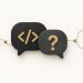 Two large speech bubbles containing simple code brackets beside a question card and branching route.